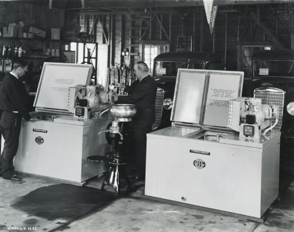 R.H. Bunker and N.H. Dover stand next to milk coolers and cream separators on display at an International Harvester dealership.