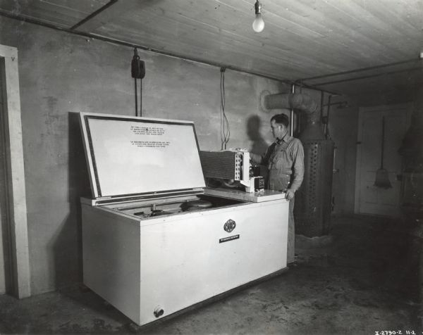 H.W. Griswold stands beside a McCormick-Deering 8-can milk cooler.