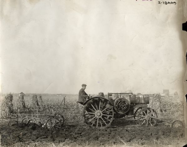 A man plowing a field with a Titan 10-20 H.P. tractor and a Janesville plow.