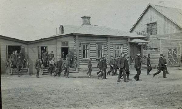 Men leaving an International Harvester factory building in Russia. The original caption reads: "employment office, timekeeping office, etc.; entrance gate; Lubertzy [Works]."