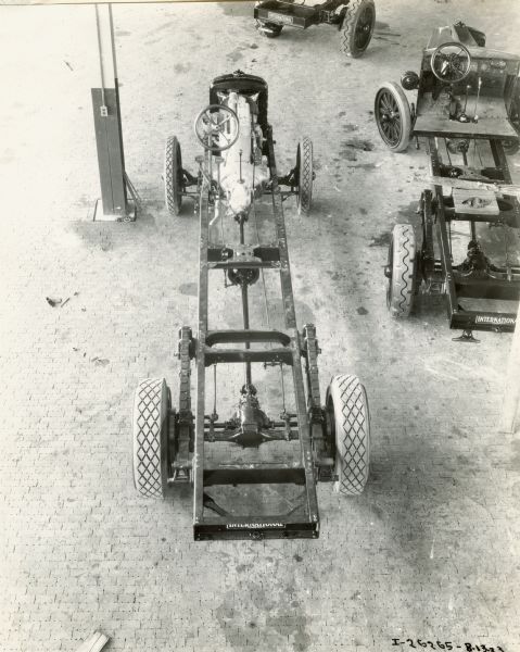 Overhead view of an International Model 63 truck chassis on what appears to be a factory floor.