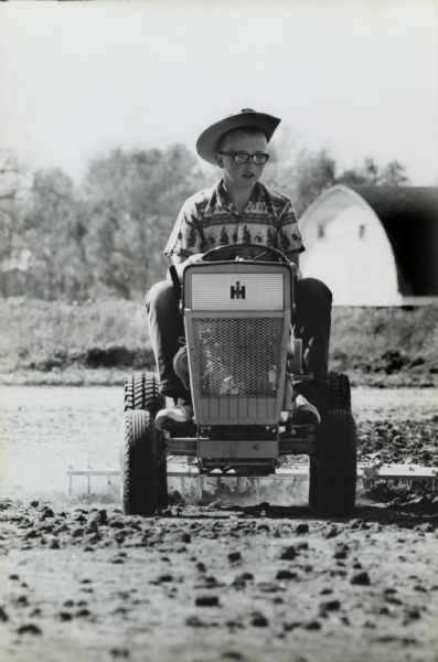 Thirteen-year-old student farmer John "Butch" Quirk planting rows of corn with the aid of his Cub Cadet tractor.