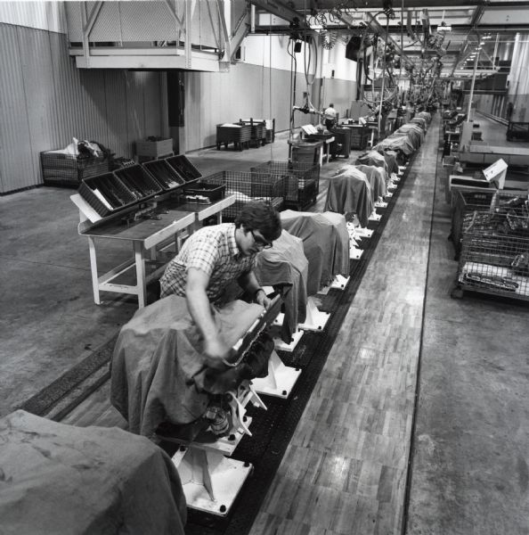 An International Harvester employee examines a component on the assembly line at West Pullman Works.