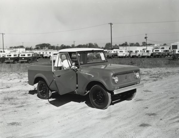 Front and side view of an International Harvester right-hand drive Scout with the driver-side door open.
