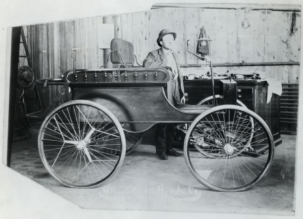 George Ellis is standing beside an experimental automobile, possibly in the basement of John F. Steward. Both men worked for the Deering Harvester Company before 1902.