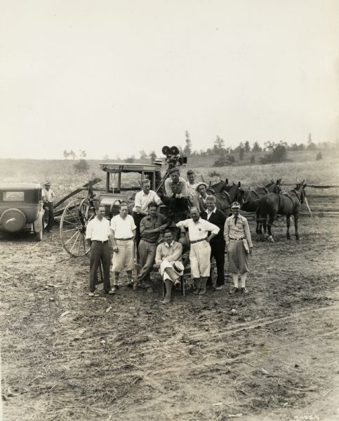 A group of eleven men (possibly cast and crew members) gather for a group portrait. The photograph was taken on the set at Walnut Grove of the Fox Hearst film "Romance of the Reaper." The film was produced by International Harvester to celebrate the Reaper Centennial.