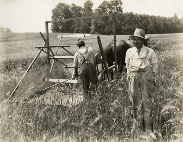 A production still for the Fox Hearst film "Romance of the Reaper". The film was produced by International Harvester at Walnut Grove to celebrate the Reaper Centennial. Caption on back of photograph reads: "Testing 1831 reaper. Jo Anderson (played by Harry Wilson) and Dan Smith."