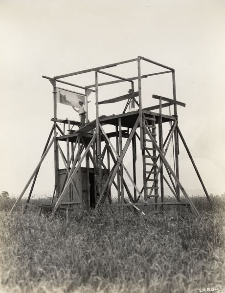 A photograph from the set of the Fox Hearst film "Romance of the Reaper". The film was produced by International Harvester at Walnut Grove to celebrate the Reaper Centennial. Caption on back of photograph reads: "Scaffolding with two platforms, the lower one for mounting of glass background screen and the upper one for the camera."