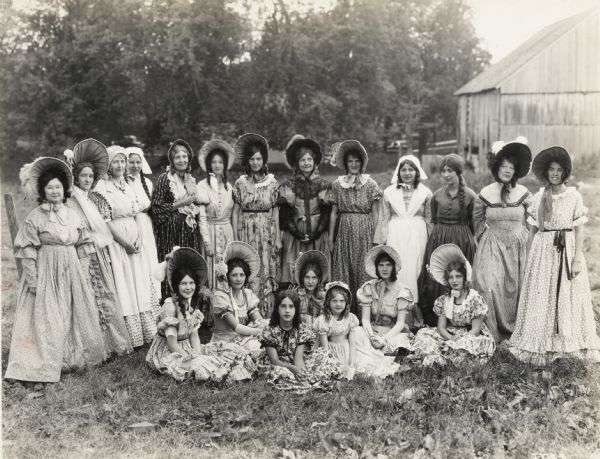A production still for the Fox Hearst film "Romance of the Reaper." The film was produced by International Harvester at Walnut Grove to celebrate the Reaper Centennial. A group of women in period costume pose on or near location for the film "Romance of the Reaper". Many of the actors and extras for the film were local residents.