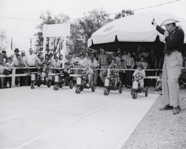 Children at starting line of toy pedal tractor race near the International Harvester exhibit at the World's Conservation Exposition and Plowing Contests, September 17-20.