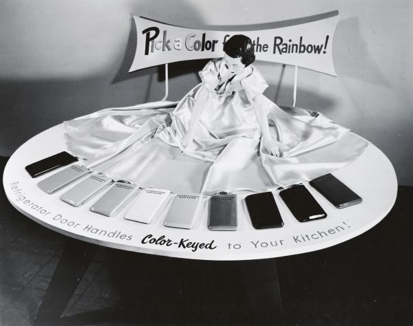 A female mannequin kneels behind ten color swatches for refrigerator door handles. Text on the display reads, "Pick a Color from the Rainbow!" and "Refrigerator Door Handles Color-Keyed to Your Kitchen!" The display may have been in the International Harvester headquarters showroom in Chicago, Illinois.