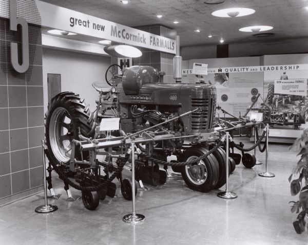 Farmall 400 propane tractor and a 455 Farmall Cultivator on display in a showroom, possibly at the International Harvester headquarters in Chicago, Illinois.