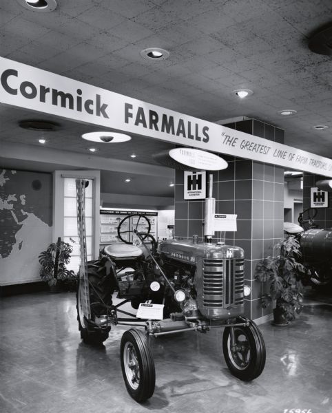 A Farmall 100 tractor on display in a showroom. The showroom may have been at the International Harvester headquarters in Chicago, Illinois.