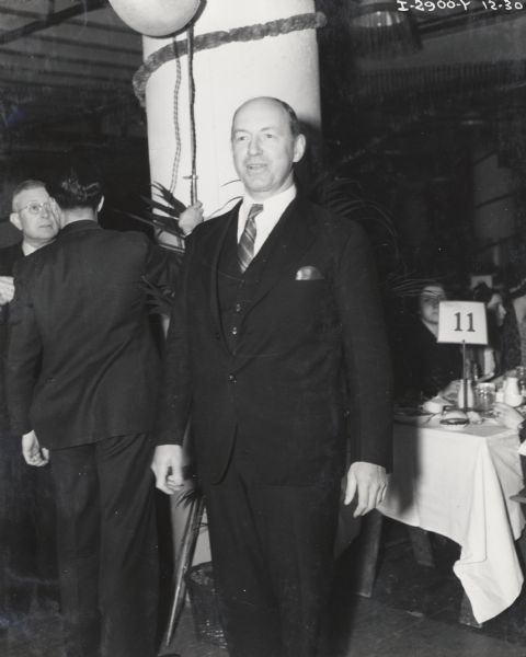 George E. Rose, Superintendent of the Wisconsin Steel Works (factory) at a 4-H club award event. Original caption reads: "Geo. E. Rose, general superintendent, Wisconsin Steel Works, caught at the post by the candid camera on his way to be host at one of the 4-H Club tables."