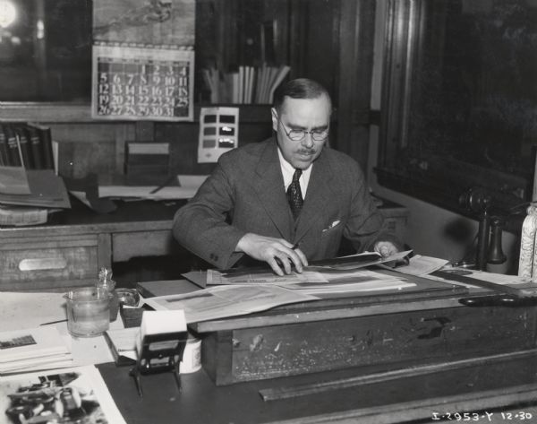 Art Director G.V. Johnson, of International Harvester's Advertising Department in Chicago, sitting at his desk.