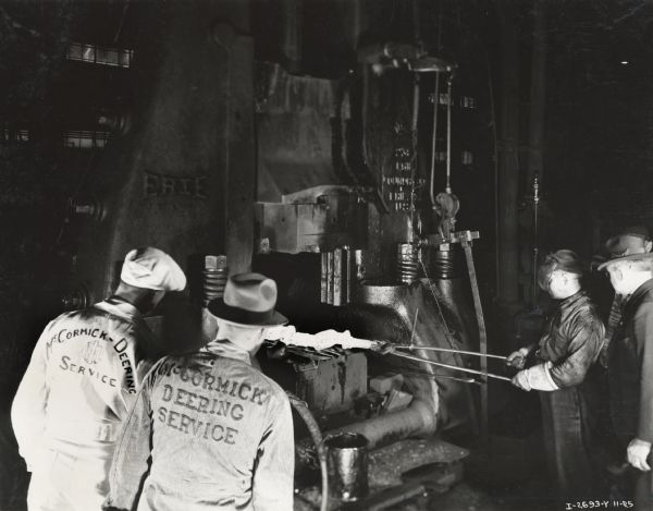 Branch service managers watching the forging of a crank shaft at Tractor Works (factory). Original caption reads (in part): "Taken by McQuinn".