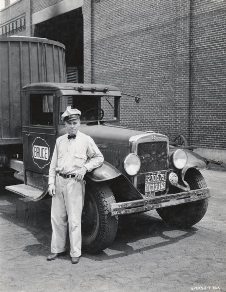 Truck driver Rudgil C. Smith standing next to his International truck. The name "Bruce" is printed on the passenger side door. Original caption reads: "Rudgil C. Smith - Safety Driver." Mr. Smith may have been the recipient of a safe-driving award sponsored by International Harvester.