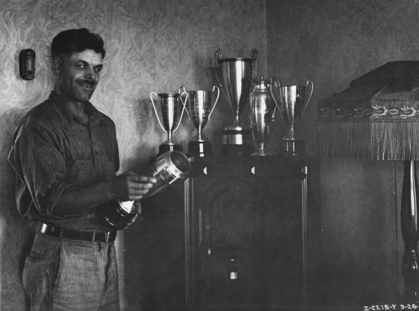 Plowing champion Carl Shoger with his trophies. Original caption reads: "Carl Shoger and his six cups won at Wheatland Plowing Contest."