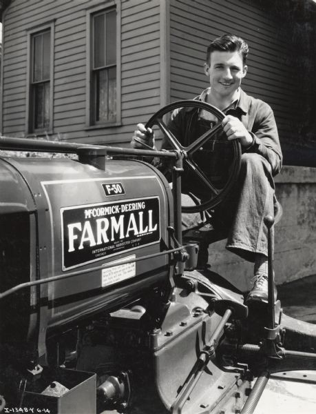M. Ogden Riddle, National 4-H farm accounting champion, sitting on a Farmall F-30 tractor. Photograph taken by H.C. Ray.