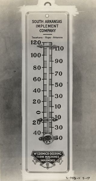 A thermometer advertising an International Harvester dealership. The text on the thermometer reads: "South Arkansas Implement Company" and "McCormick-Deering Farm Machines and Implements."