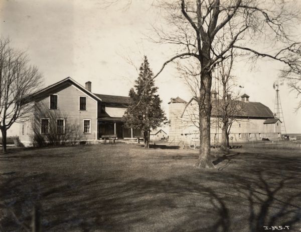 Farmyard of O.W. Anderson with farmhouse, barn, silo, and windmill. There is a platform swing in the yard.