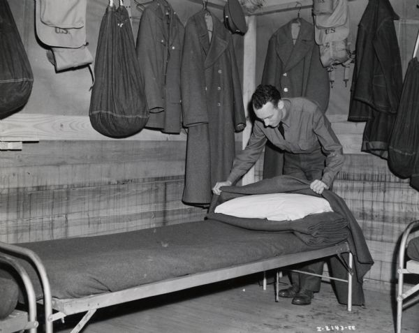 Draftee Charles J. Richard, a former International Harvester employee from Oklahoma City, makes a bed at Fort Sill. A complete story was published in the August, 1941 edition of <i>Harvester Works</i>.