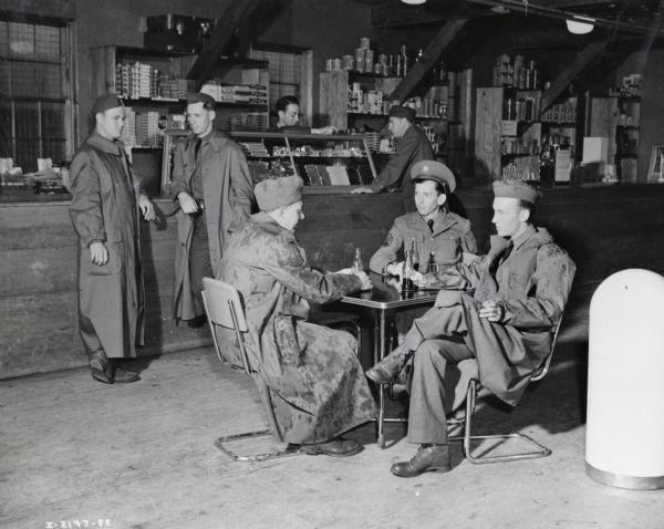 A group of men sit in a store and drink soda at Fort Sill. Draftee Charles J. Richard is among the men. Richard was a former International Harvester employee from Oklahoma City. A complete story was published in the August, 1941 edition of <i>Harvester Works</i>.