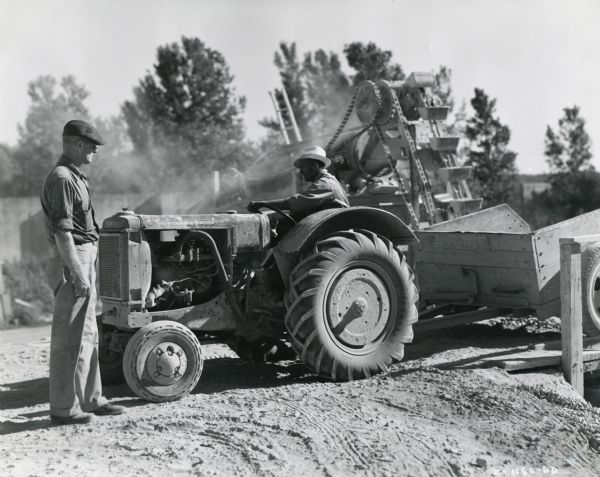 Men work with an International I-12 tractor owned by the city of Davenport.