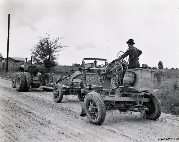 Men operating an International ID-40 industrial tractor and an Adams grader on a dirt road. Original caption reads: "International ID-40 Diesel wheel tractor owned by county shown at work just outside Jackson, Mississippi. It is shown operating Adams No. 84 10-foot blade. The ID-40 is a big 'leader' in the hard-hitting selling campaign of L.R. Simmons, president, the Mississippi Road Supply Company, Jackson, Mississippi. (More in article "Diesel Wheel Tractor Simmons' Feature Sales Item.)"