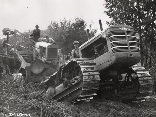 Four men with an International TD-18 crawler tractor (TracTracTor) and an Adams Elevating Grader. Caption on photograph reads, "A TD-18 and 42-inch Adams Elevating Grader powered by a U-10 Power Unit." Photograph taken in Ledue, Alberta, Canada.