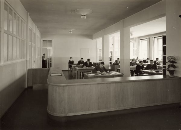 Workers at desks in the head office ("hauptburo") of International Harvester's branch house in Breslau, Germany.