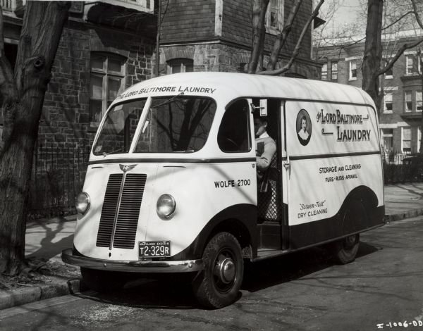 Man at the wheel of an International model D-15-M truck with a 113-inch wheelbase and a Metro body. The truck was one of thirteen Internationals owned by the Lord Baltimore Laundry.