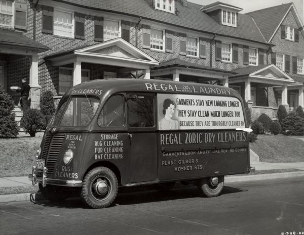 International model D-15-M truck with a 113-inch wheelbase and a Metro body owned by the Regal Laundry.  According to the original caption, the truck was one of five in the company's fleet. The truck is parked in front of a what appears to be condominiums. The side of the truck has an advertisement with a picture of a woman and the text: "garments stay new looking longer, they stay clean much longer too because they are thourghly [sic] cleaned by Regal Zoric Dry Cleaners."