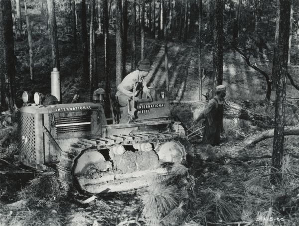 Men use an International TD-9 TracTracTor (crawler tractor) with Carco(?) winch in a logging operation.