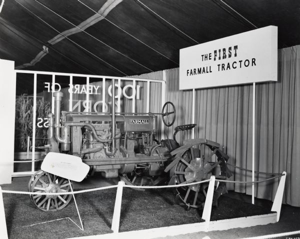 Farmall Regular tractor on display, likely at International Harvester's "100 Years in Chicago" celebration in Chicago. A sign identifies the tractor as the "First Farmall."