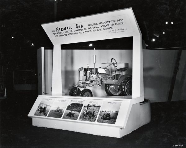 A cutaway version of a Farmall Cub tractor on display, probably at International Harvester's "100 Years in Chicago" celebration. A sign above the tractor reads: "The Farmall Cub tractor presents the first opportunity for the operator of the small acreage or family-size farm to mechanize at a price he can afford -- John L. McCaffrey."