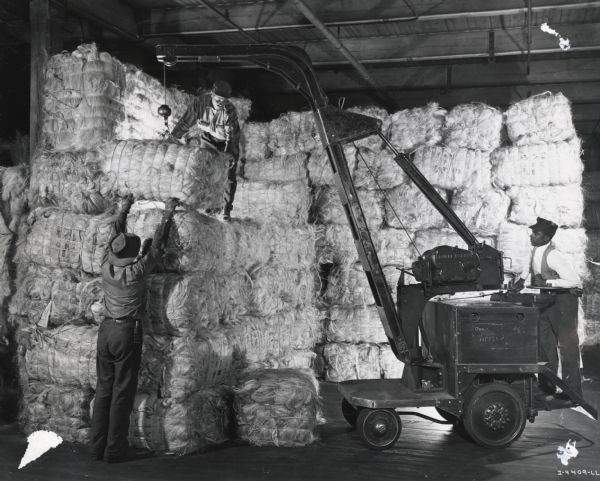Factory workers stack bales of twine in a warehouse at the McCormick Twine Mill.