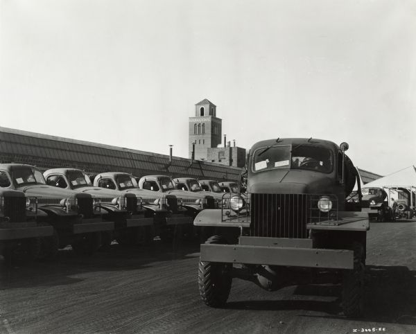 International military trucks bound for Russia during World War II. Original caption reads: "The trucks are the military model No. M-5-6, originally sold to the United States Army. These trucks have been diverted under the Lease-Lend Program to Russia." A tower in the background may be part of the company's Ft. Wayne Works.