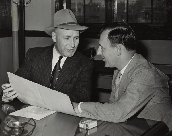 Factory superintendent at St. Paul Works. "Medium Caliber Artillery Gun Manufacture. J.E. Harris, left, superintendent of St. Paul Works, confers with M.V. Keeler, assistant superintendent of the works, on plans for putting the plant in operation at the earliest possible date."