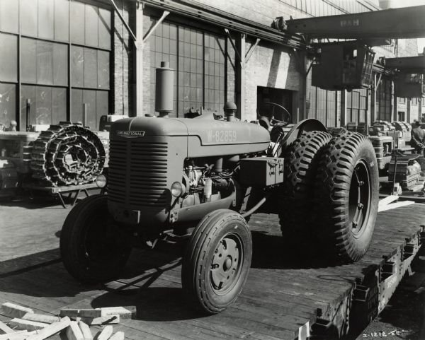 International military tractor on a rail car, most likely at Internaitonal Harvester's Tractor Works (factory). Original caption reads: "A wheel-type Diesel powered tractor built by International Harvester Company for the Army. This tractor, with approximately 41 horsepower pull at the drawbar, is equipped with dual rear wheels with tread design calculated to give the tractor maximum pulling power under all types of operating conditions. Here the tractor is ready for shipment to the Army."