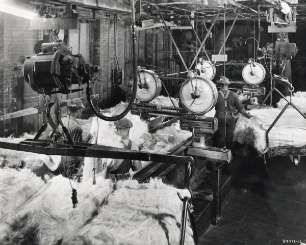 Factory workers work with machines to turn sisal fiber into binder twine, possibly at the McCormick Twine Mill.