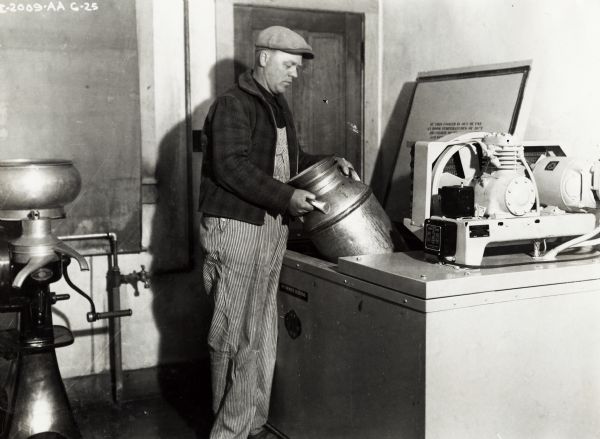 Edward Beyer stands with a milk can, cream separator, and McCormick-Deering cooler on his farm.