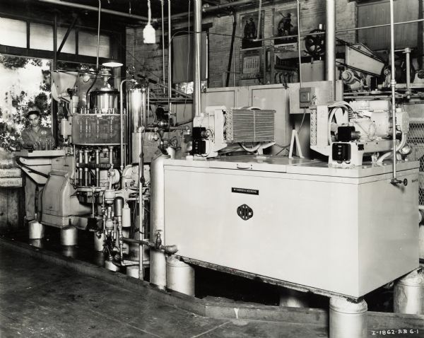 A McCormick-Deering cooler at the Buster Bottling Company. A worker with a "Drink Orange Crush" hat is moving soda bottles to a crate.