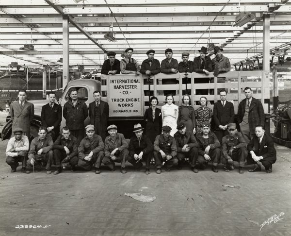 Factory workers pose at International Harvester's Indianapolis Works. Original caption states: "First 26 employees at the new Indianapolis truck engine works."