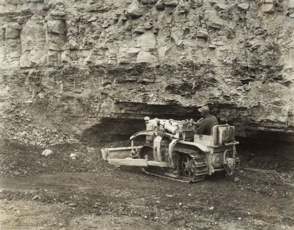 Worker using an International TracTracTor (crawler tractor) in a mining operation. Original caption states: "owned by Possum Hollow Coal Company. Building roads, spreading shale, cleaning off coal in pit, pulling in equipment, and general work around the coal mine. Using 11 gallons of fuel in nine hours. Operating very satisfactorily."