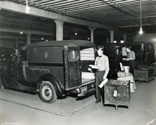 Men loading delivery trucks used by Emery Bird Thayer Dry Goods Company.
