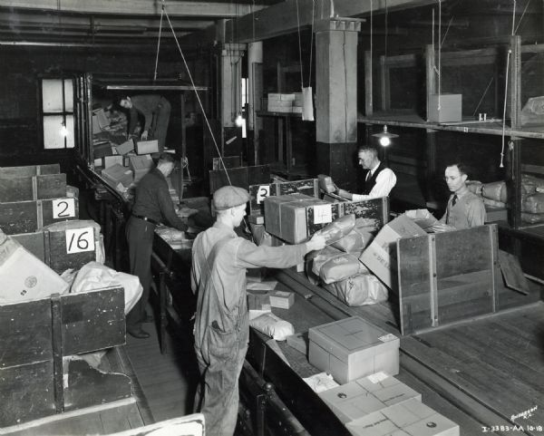 Slightly elevated view of men sorting packages in the shipping department of Emery Bird Thayer Dry Goods Company.