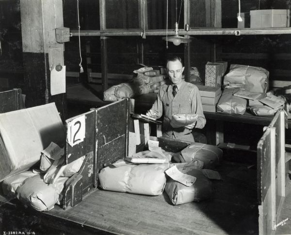 A man sorting packages in the shipping department of the Emery Bird Thayer Dry Goods Company.