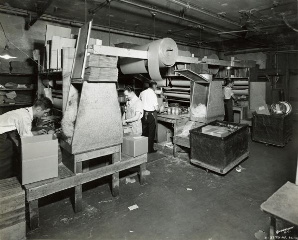 Men wrapping parcels in the wrapping department of the Emery, Bird, Thayer Dry Goods Company.