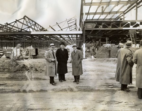 Men inspect Indianapolis Works, then under construction. The original caption reads: "Photo taken during inspection of Indianapolis Truck Engine Works, then under construction.  Present on the tour were Harvester officials, Indianapolis businessmen and prominent state and city officials. (Left to right) H.N. Ross, then Cen. Dist. Mgr.; C.F. Gibson, Ass't. B.M. Indianapolis M.T. Br.; T.H. Hildebrand, Ass't Dist. Mgr. Cen. Dist."